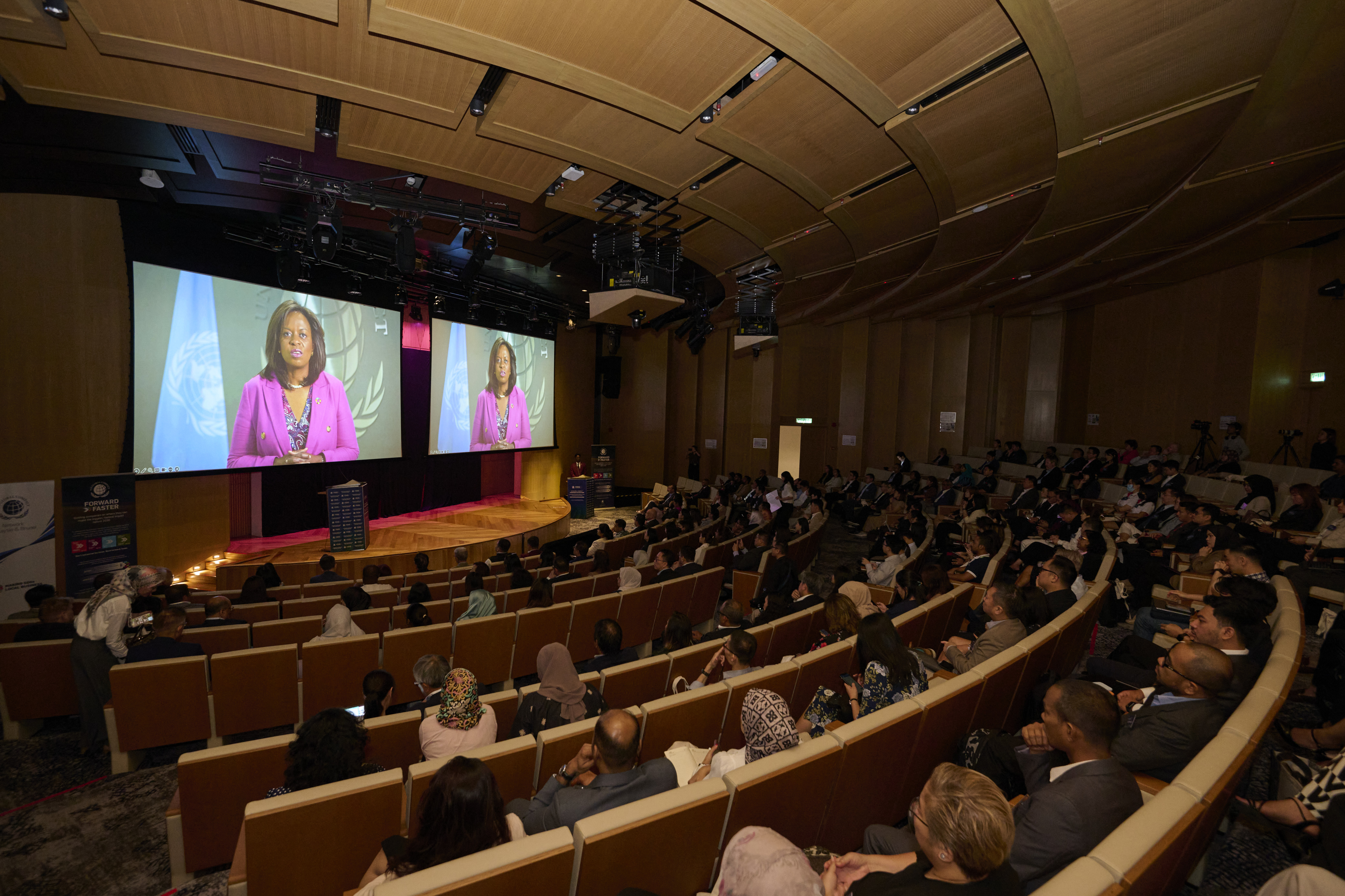 auditorium of people watching Sanda Ojiambo address the crowd