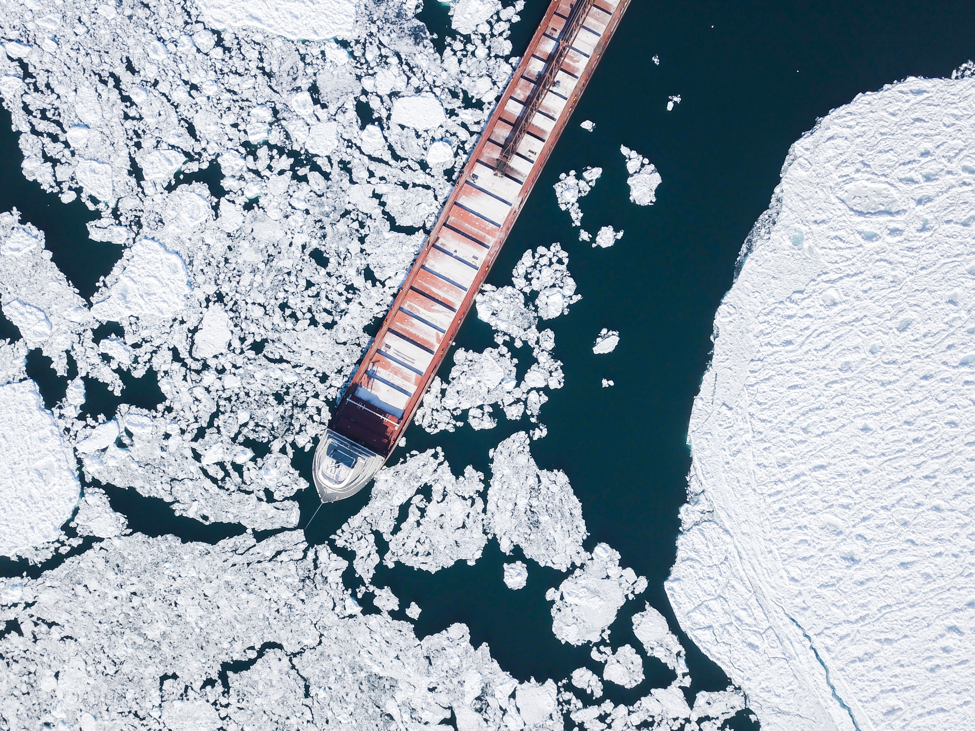 boat transporting containers going through ice