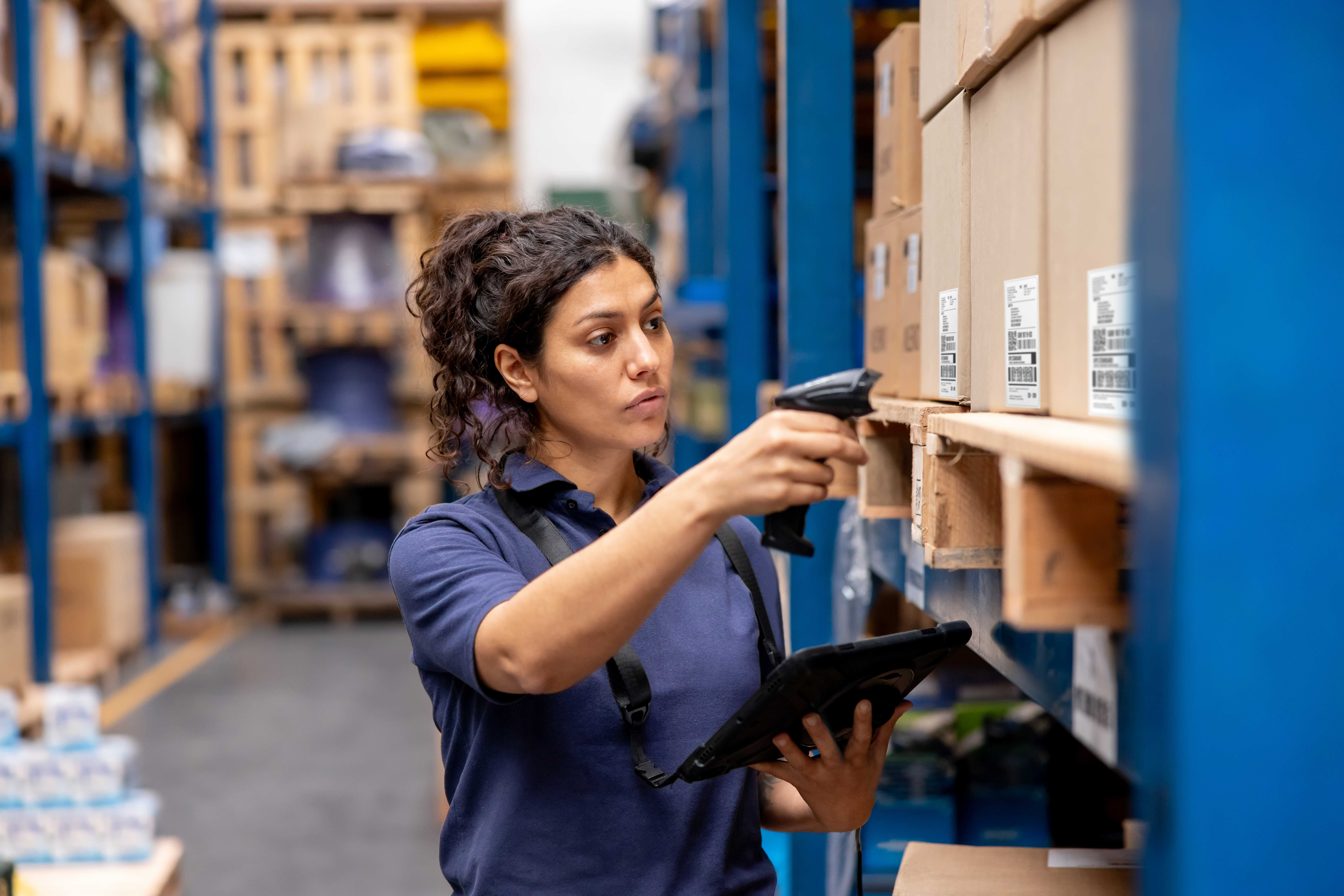 woman scanning boxes in a warehouse 
